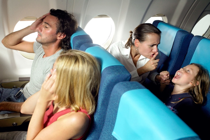 Пассажиры самолета закрывают уши руками